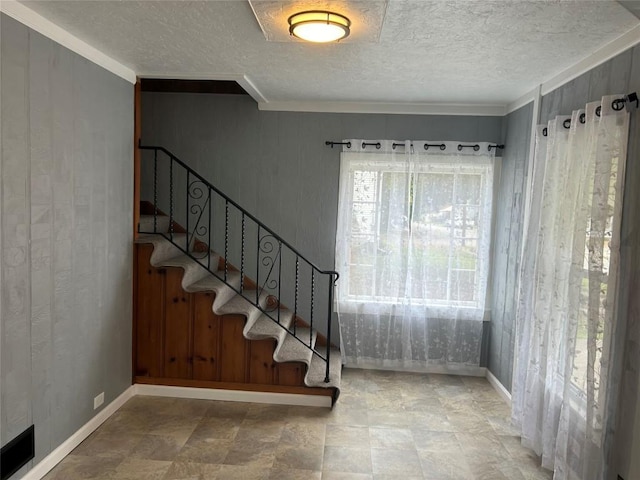 entrance foyer with crown molding and wooden walls