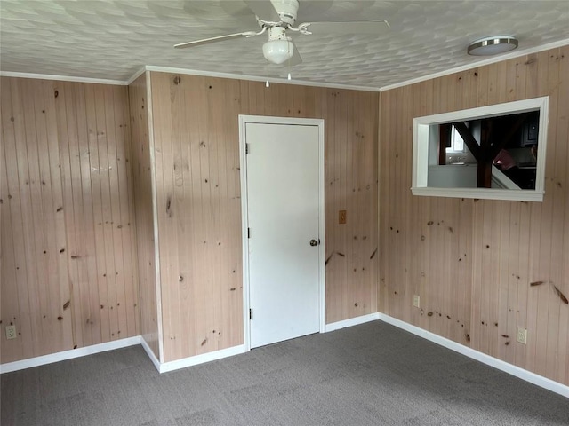 carpeted empty room featuring ceiling fan, ornamental molding, and a textured ceiling