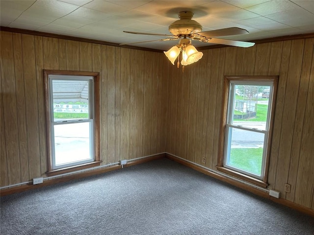 spare room with carpet, plenty of natural light, ceiling fan, and ornamental molding