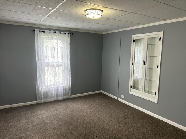 spare room featuring a paneled ceiling and carpet floors