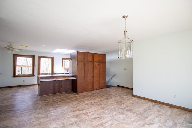 5130 W Stancliff Rd, Mckean, PA 16426 - kitchen with brown cabinets, hanging light fixtures, a ceiling fan, and baseboards