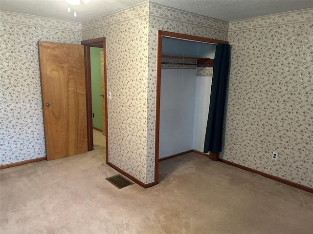 unfurnished bedroom with carpet floors and a closet