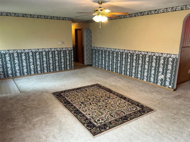 carpeted empty room featuring ceiling fan