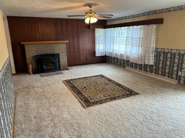 living room with ceiling fan, wooden walls, and a textured ceiling