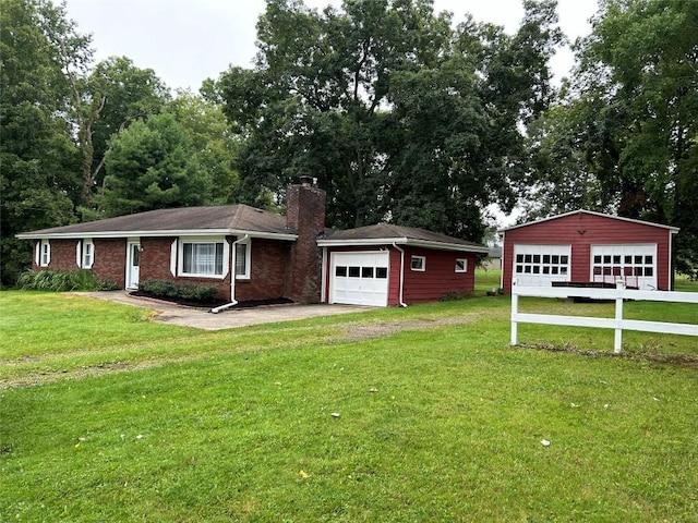 single story home with a garage, a front lawn, and an outdoor structure