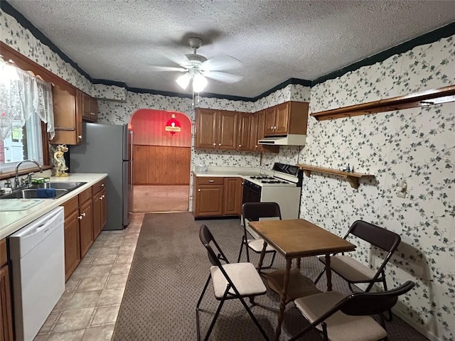 kitchen with a textured ceiling, ceiling fan, white appliances, and sink