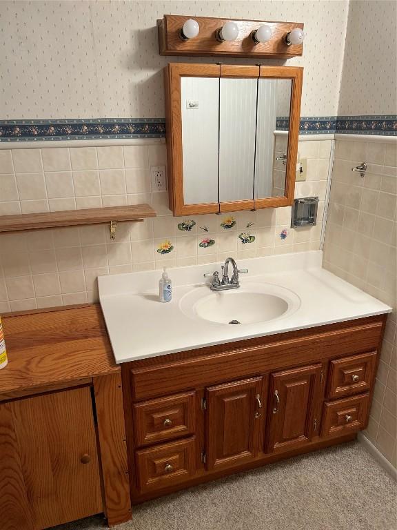 bathroom featuring vanity and tile walls