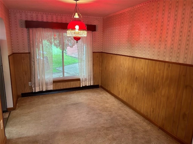 unfurnished dining area featuring wood walls and light colored carpet