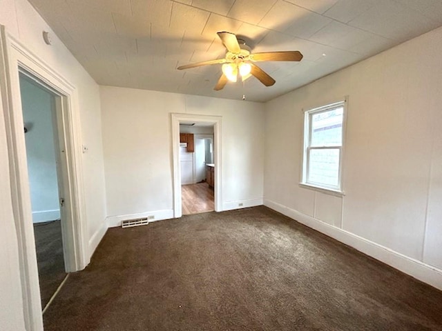 unfurnished bedroom featuring ensuite bathroom, ceiling fan, visible vents, baseboards, and carpet