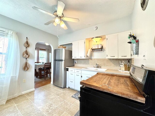 3524 French St, Erie, PA 16504 - kitchen featuring freestanding refrigerator, arched walkways, decorative backsplash, a textured ceiling, and ceiling fan