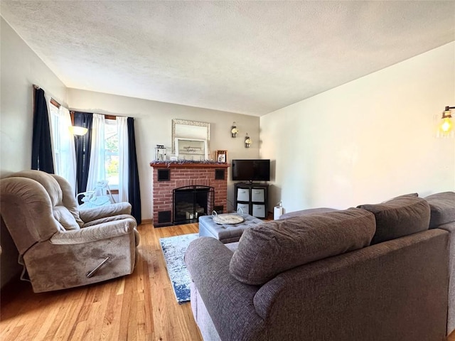 3524 French St, Erie, PA 16504 - living area with light wood-type flooring, a brick fireplace, and a textured ceiling