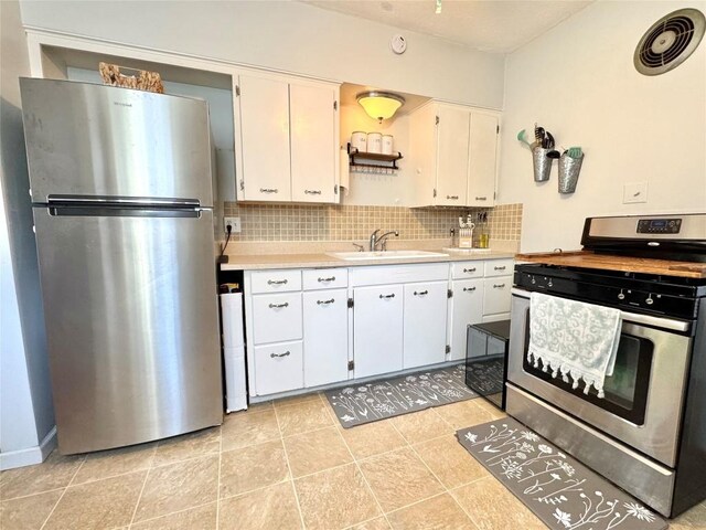 3524 French St, Erie, PA 16504 - kitchen with appliances with stainless steel finishes, light countertops, backsplash, white cabinetry, and light tile patterned flooring