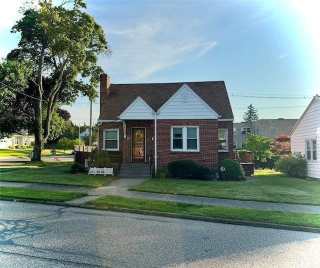 3524 French St, Erie, PA 16504 - view of front of home featuring brick siding, a chimney, a front yard, and roof with shingles