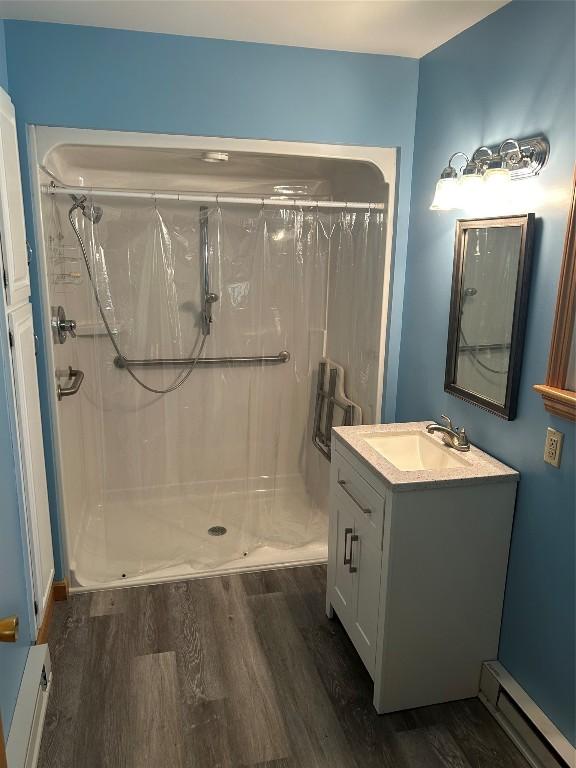 6848 6th Hwy, Linesville, PA 16424 - full bathroom with a baseboard heating unit, wood finished floors, and a shower stall