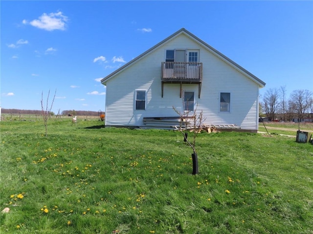 rear view of property with a lawn and a balcony