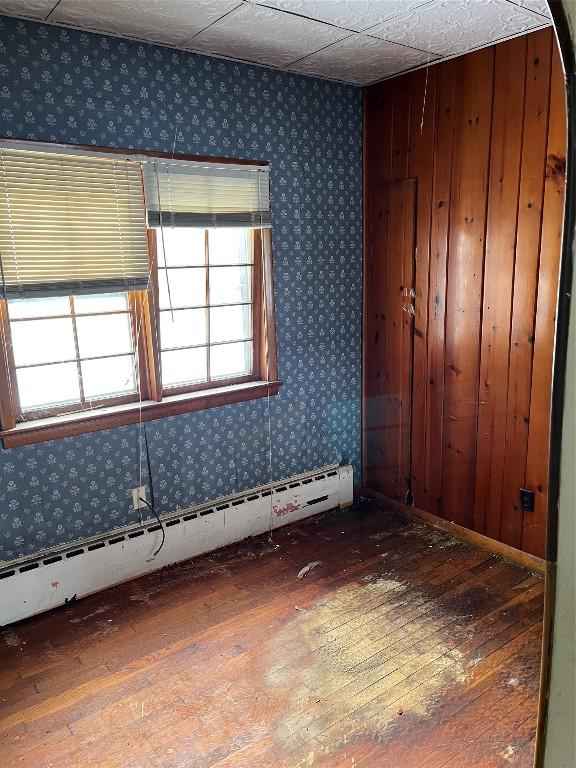 spare room with hardwood / wood-style flooring and a baseboard heating unit