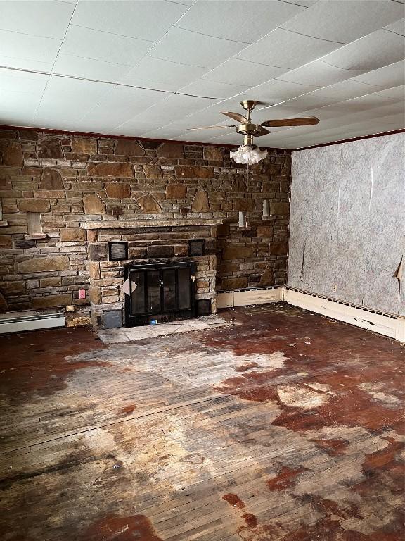 unfurnished living room featuring a fireplace, hardwood / wood-style flooring, ceiling fan, and a baseboard heating unit