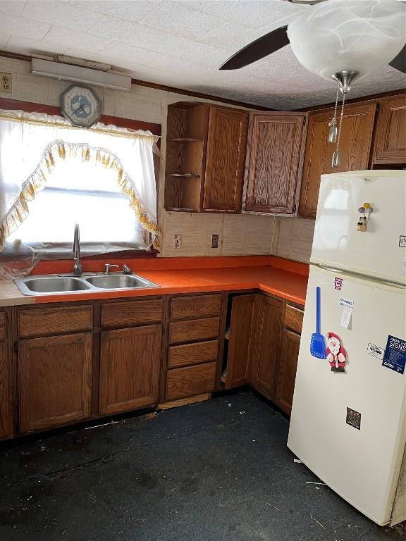 kitchen featuring white refrigerator, ceiling fan, and sink