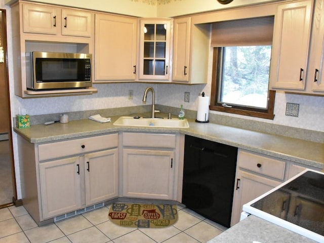 kitchen with visible vents, a sink, light countertops, black dishwasher, and stainless steel microwave