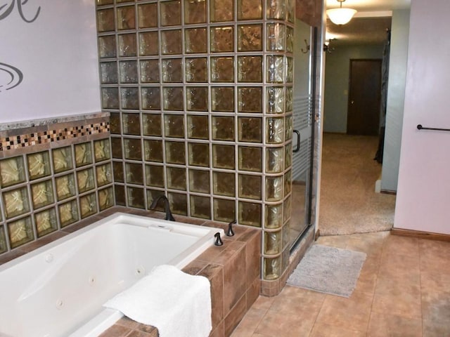 full bath with tile patterned flooring, a tub with jets, a stall shower, and baseboards