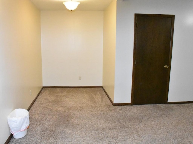 empty room featuring baseboards and carpet