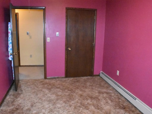 unfurnished room featuring baseboard heating and carpet flooring