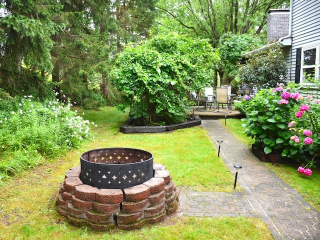 view of yard featuring a wooden deck and a fire pit