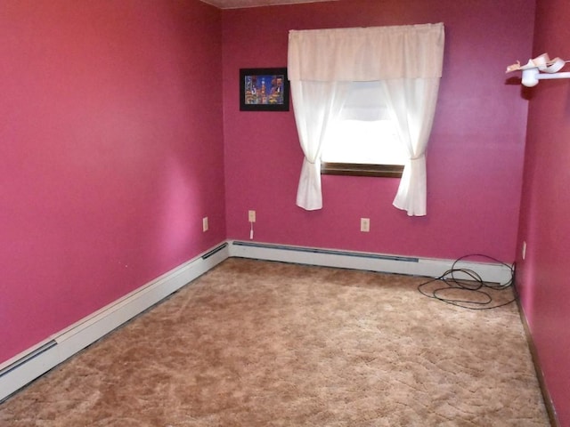 empty room featuring a baseboard heating unit, baseboards, and carpet floors