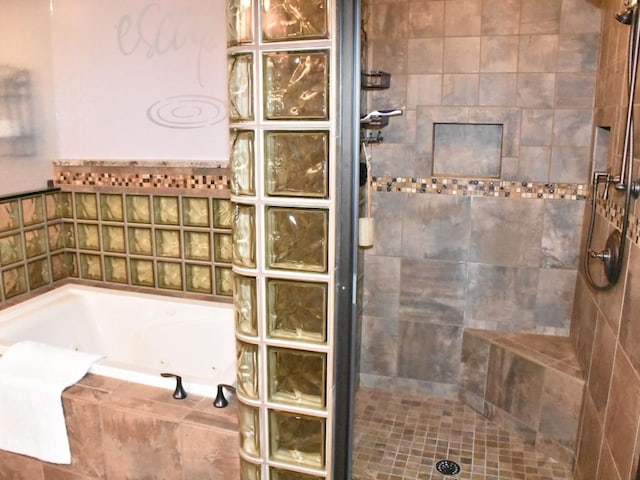 full bathroom featuring a jetted tub and a tile shower