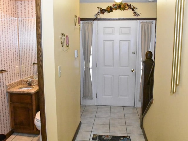 hall featuring light tile patterned flooring and a sink