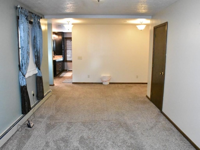 empty room with baseboards, light carpet, and a baseboard radiator