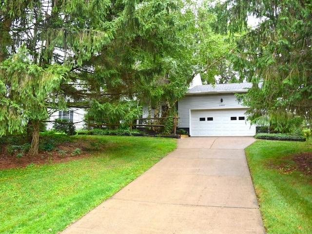 obstructed view of property with a garage, driveway, and a front lawn