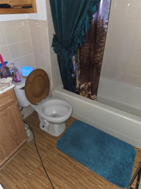1146 W 5th St, Erie, PA 16502 - full bathroom with toilet, shower / bath combo with shower curtain, tile walls, wood finished floors, and vanity