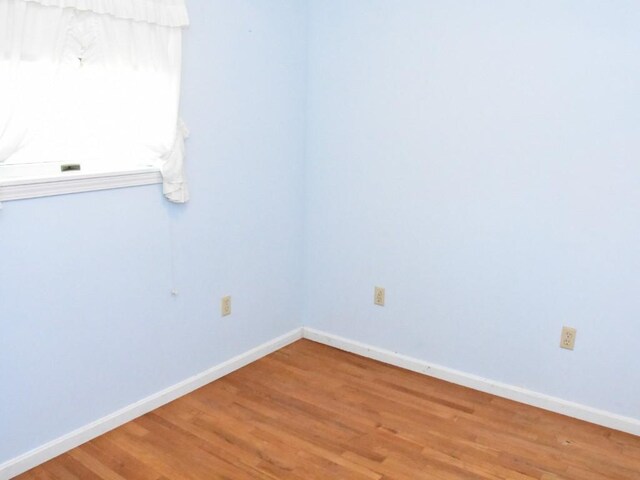 spare room with light wood finished floors and baseboards