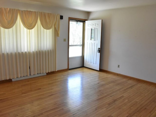 empty room with light wood finished floors and baseboards
