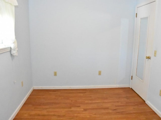 spare room with light wood finished floors and baseboards