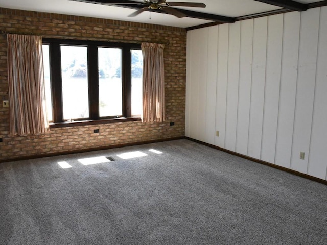 carpeted empty room featuring brick wall and ceiling fan