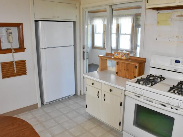 kitchen featuring light countertops, light floors, and white appliances