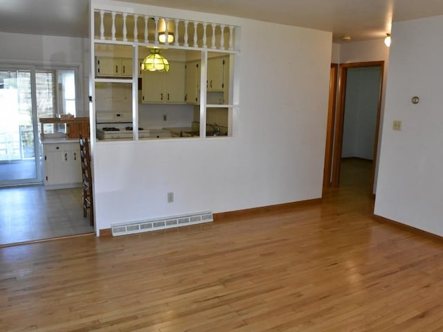 empty room featuring visible vents, light wood finished floors, and baseboards
