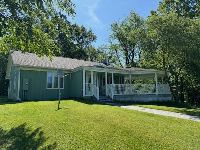 view of front of house with a porch and a front yard