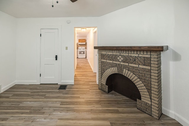 329 27th St, Erie, PA 16504 - unfurnished living room with wood finished floors, a ceiling fan, and a fireplace