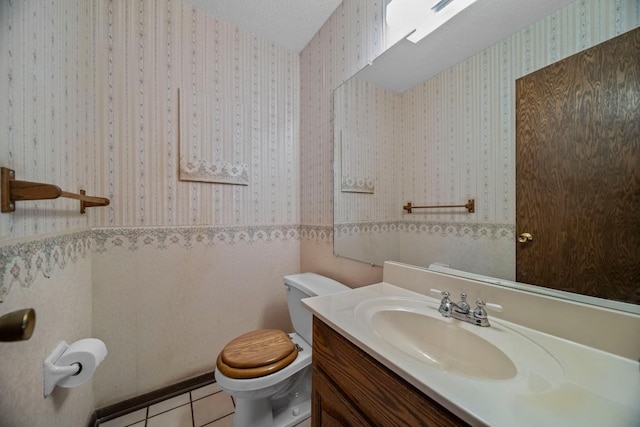 bathroom featuring a textured ceiling, tile patterned floors, vanity, and toilet