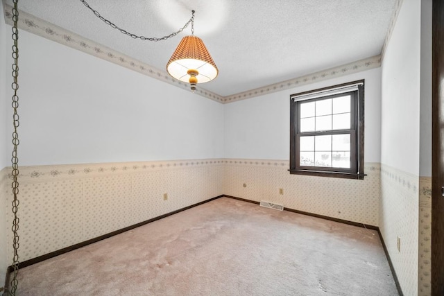 carpeted empty room with a textured ceiling