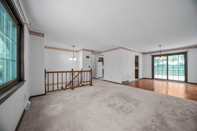 unfurnished room featuring carpet flooring and an inviting chandelier