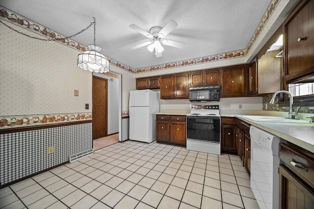 kitchen with ceiling fan, hanging light fixtures, sink, white appliances, and a textured ceiling