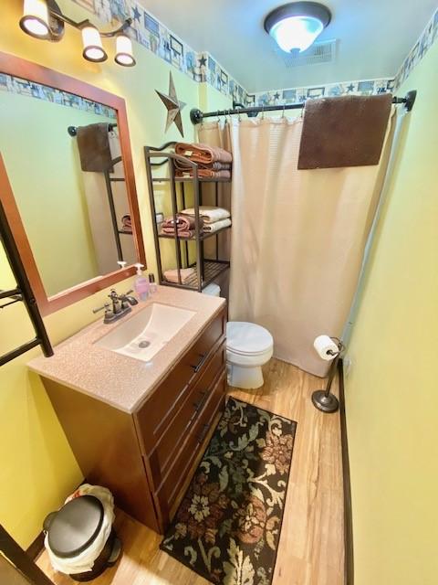 10634 N Edgewood Dr, Lake City Borough, PA 16423 - bathroom featuring wood finished floors, toilet, vanity, and curtained shower