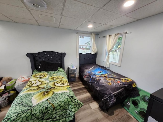 bedroom featuring hardwood / wood-style flooring and a drop ceiling