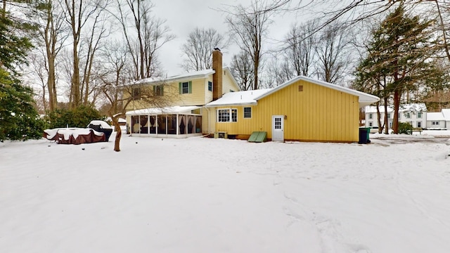 snow covered property featuring a sunroom