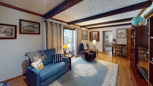 living room with beamed ceiling, wood-type flooring, and a textured ceiling