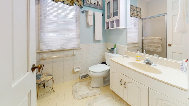 bathroom with tile patterned floors, vanity, toilet, and tile walls